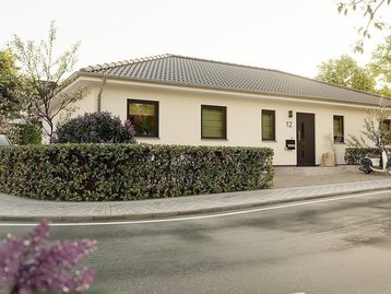 Moderner Bungalow mit Vorgarten als Beispiel für ebenerdiges Wohnen mit AN Massivhaus